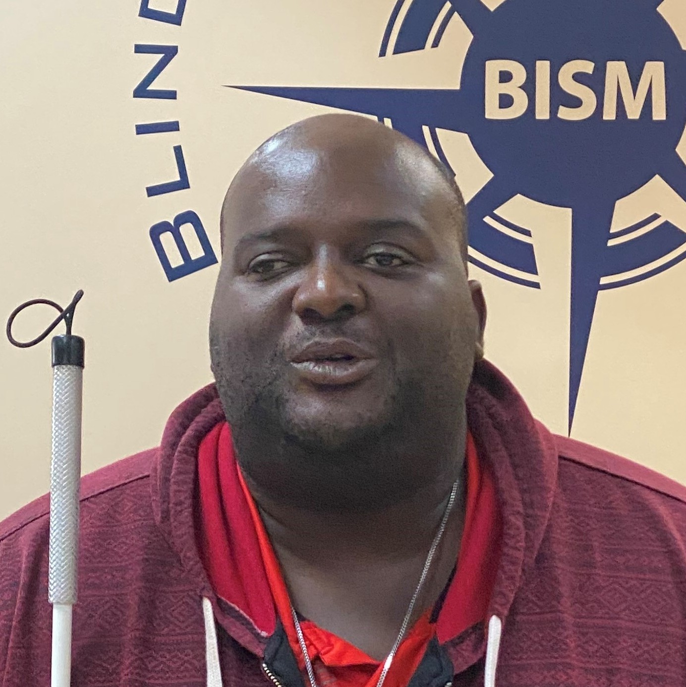 Photo of Antonio Williams standing in front of the BISM logo. Antonio looks confident and friendly.